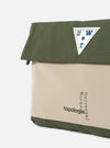 Close-up of the Topologie x Universal Works Rifle Green UW Tech Musette Medium bag. Features a green and beige color block design with the logos. Shot on a white background.