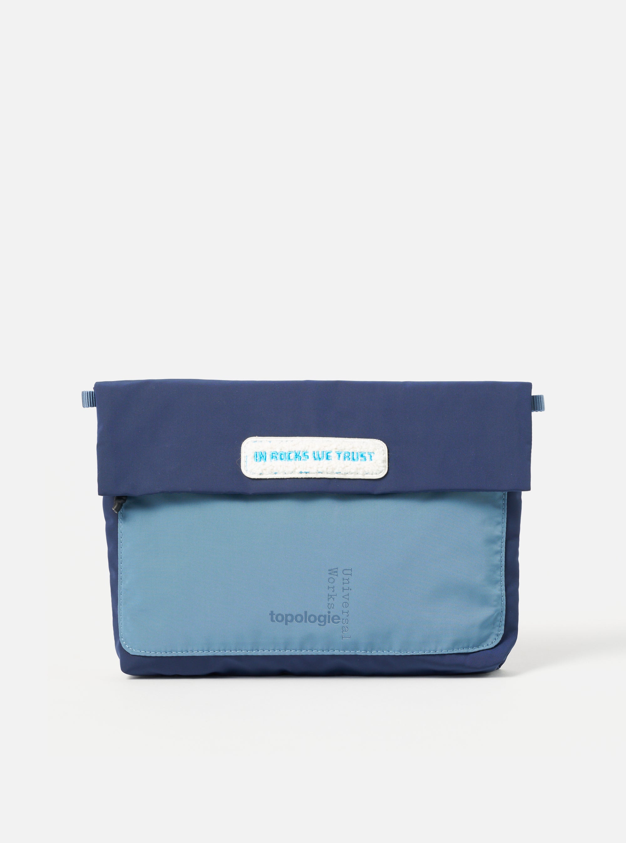 Topologie x Universal Works Insignia Blue UW Tech Musette Medium on a white background. The bag is two-tone blue with a patch that reads "IN ROCKS WE TRUST".