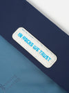 Close-up of the Topologie x Universal Works Insignia Blue UW Tech Musette Medium. Features a blue tech material with a white patch that reads "IN ROCKS WE TRUST" in blue lettering.