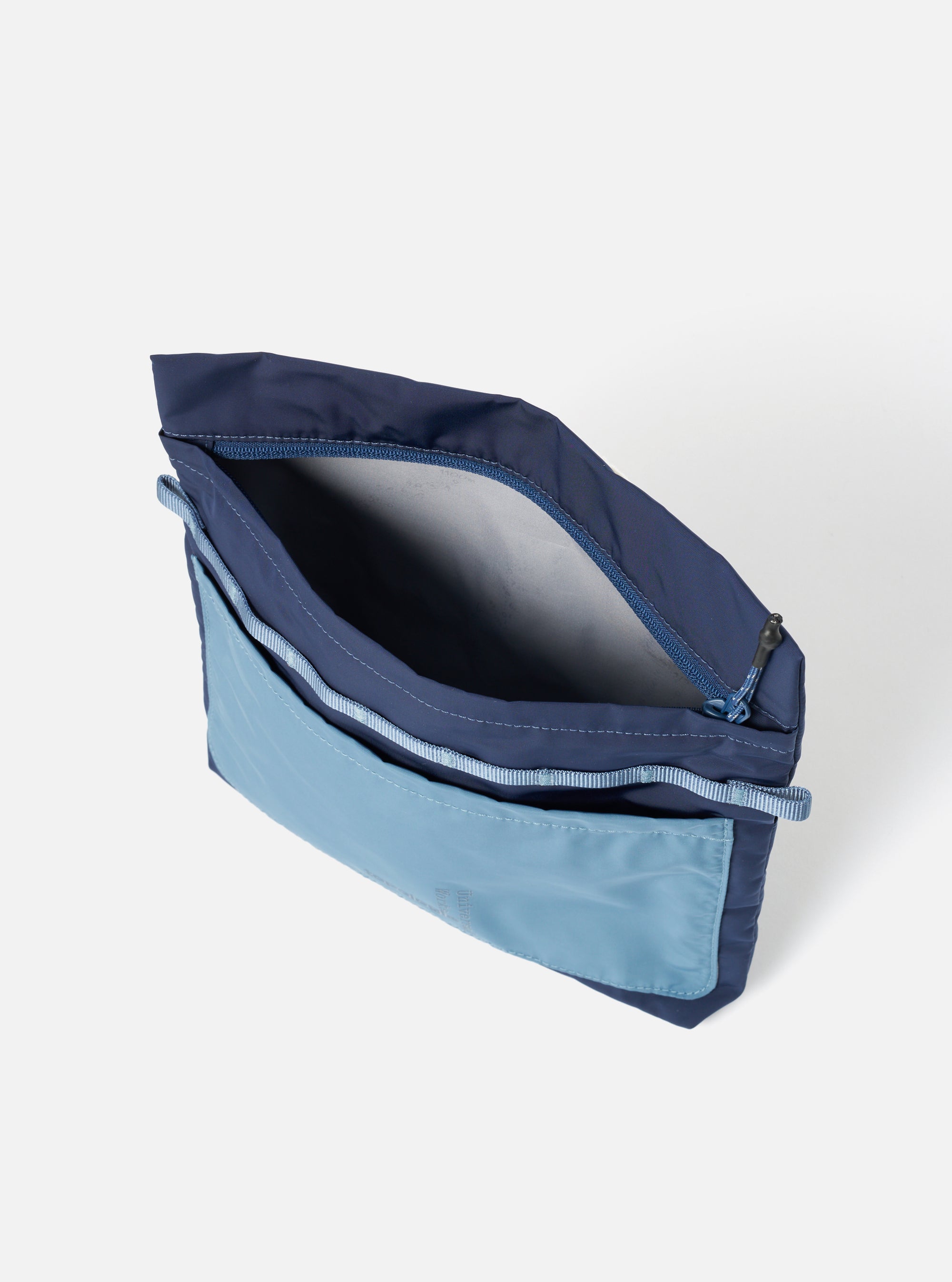The Topologie x Universal Works Insignia Blue UW Tech Musette Medium bag. It's open, showing the interior. The bag is two-tone blue, on a white background.