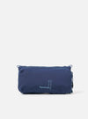 Topologie x Universal Works Insignia Blue UW Tech Bottle Sacoche Medium on a white background. The blue bag features a zip closure and drawstring detail.