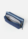 The Topologie x Universal Works Insignia Blue UW Tech Bottle Sacoche Medium, open, on a white background. The bag is blue with a gray interior and blue straps.