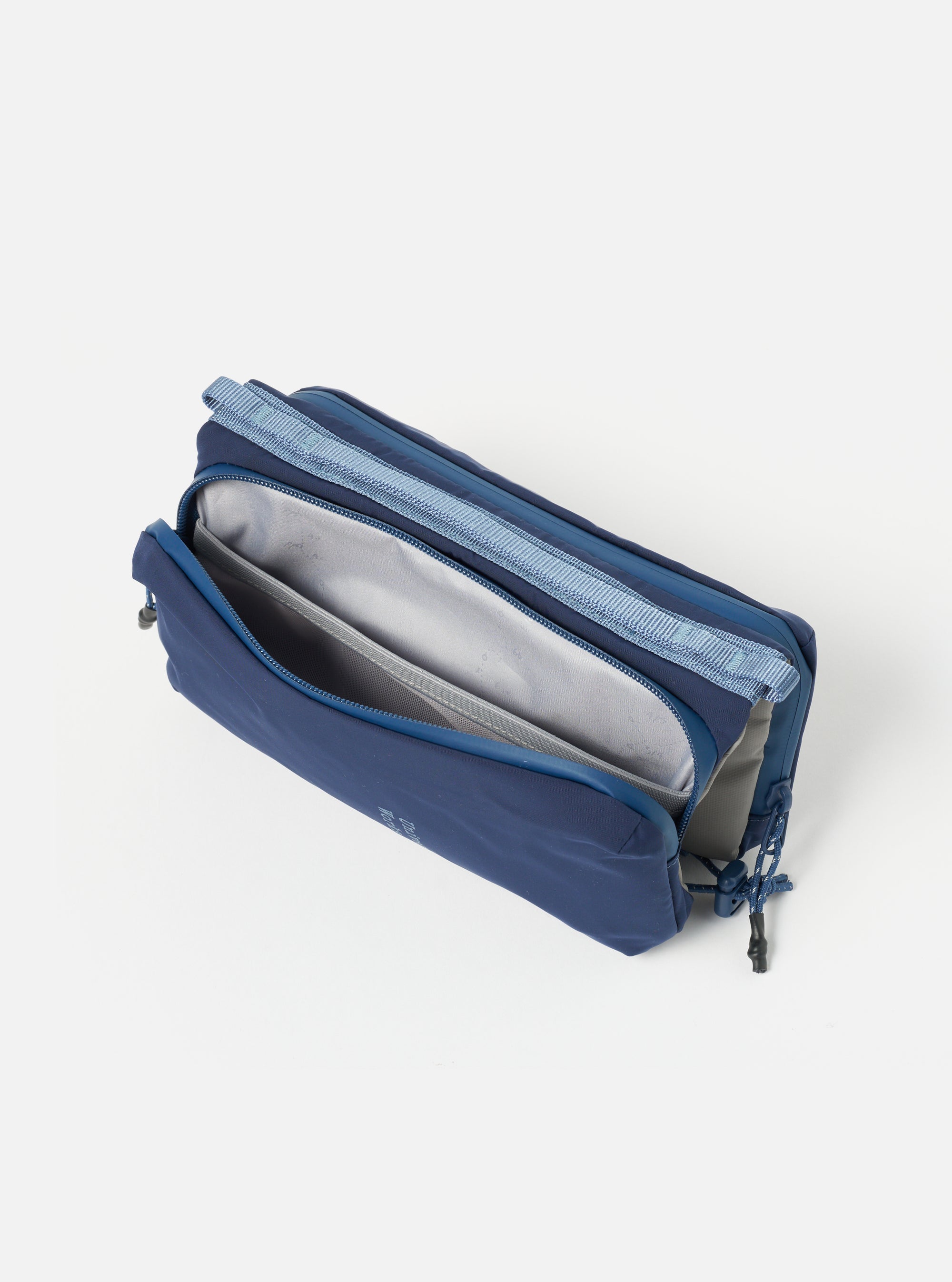 The Topologie x Universal Works Insignia Blue UW Tech Bottle Sacoche Medium, open, on a white background. The bag is blue with a gray interior and blue straps.