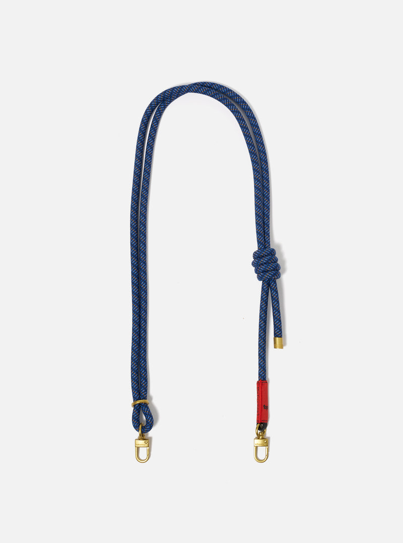 The Topologie x Universal Works Navy Hitch UW Rope 8mm Strap on a white background. The rope is blue with gold hardware and a red accent.