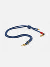 The Topologie x Universal Works Navy Hitch UW Rope 8mm Rope Strap on a white background. The strap is blue with gold hardware and red accents.