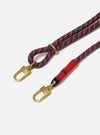 Close-up of the Topologie x Universal Works Olive Hitch UW Rope 8mm Strap on a white background. The rope is red, blue and beige with gold hardware and a red fabric section.
