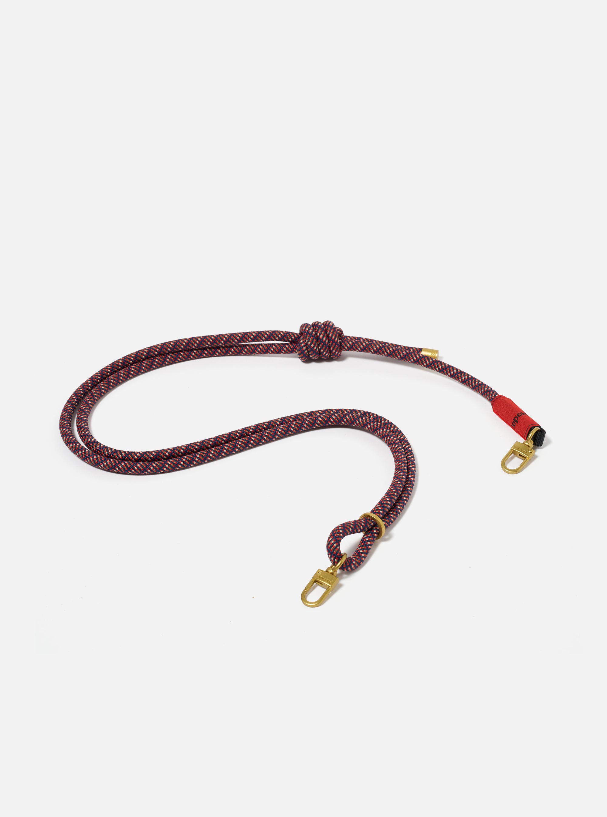 The Topologie x Universal Works Olive Hitch UW Rope 8mm Rope Strap on a white background. The rope is a mix of olive, red and navy with gold hardware.