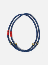The Topologie x Universal Works Navy Hitch UW Rope 10mm Rope Loop on a white background. The rope is blue with gold accents and red fabric. 