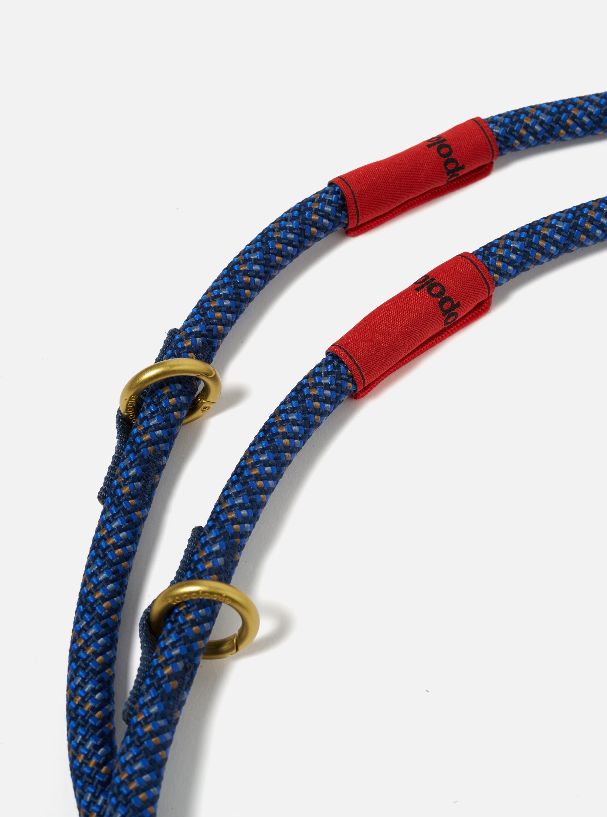 Close-up of the Topologie x Universal Works Navy Hitch UW Rope 10mm Rope Loop on a white background. The rope is blue with gold accents and has red fabric and gold metal details.