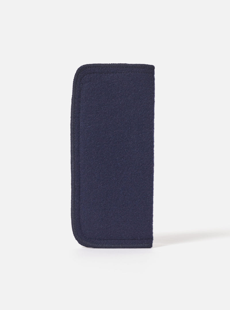 Close-up of the Navy Melton Large Glasses Case on a white surface. The case is made of navy blue melton fabric with a dark trim.