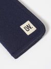 Close-up of the Navy Melton Large Glasses Case on a white surface, showing the melton wool texture and the 'UW' logo patch.