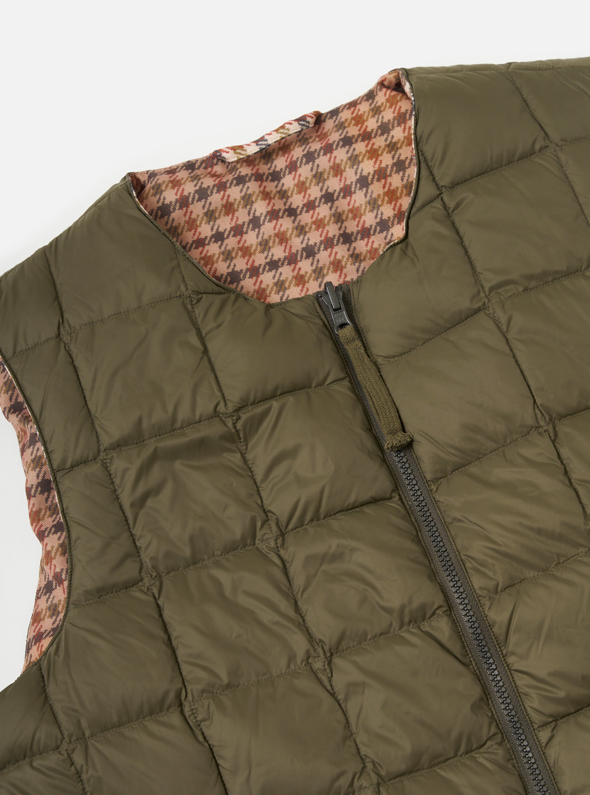 Close-up of the TAION x Universal Works Reversible Dark Olive Military Line Vest. Features a quilted dark olive side and a brown houndstooth pattern on the reverse. On a white background.