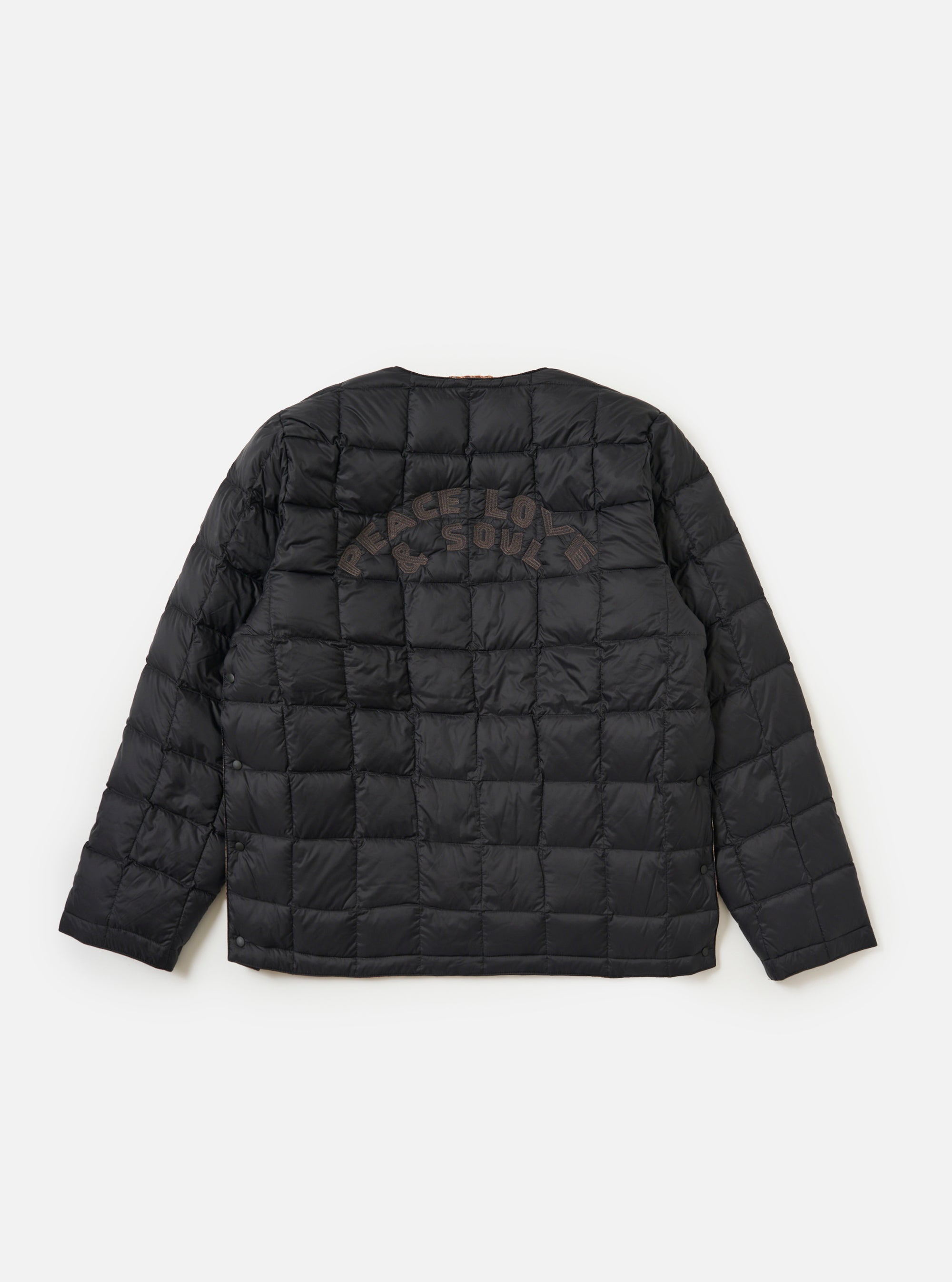 The TAION x Universal Works Reversible Black Military Line Liner Jacket, displayed on a white background. The jacket is black with a quilted pattern and "PEACE LOVE & SOUL" embroidered on the back.