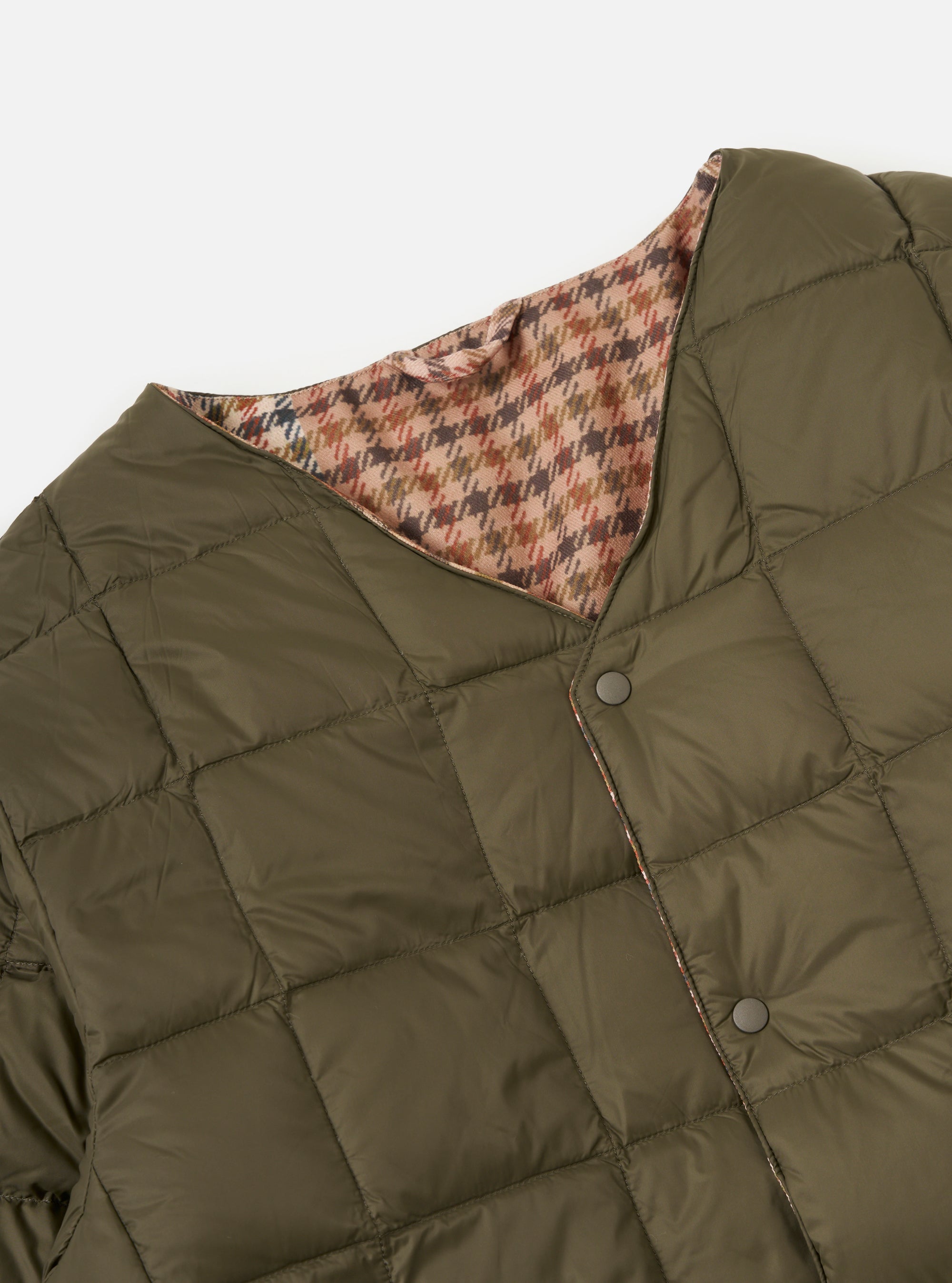 Close-up of the TAION x Universal Works Reversible Dark Olive Military Line Liner Jacket on a white background. Shows the olive quilted material and the brown houndstooth reversible side.