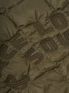 Close-up of the TAION x Universal Works Reversible Dark Olive Military Line Liner Jacket, showcasing the quilted texture and embroidered logo detail on the olive green fabric.