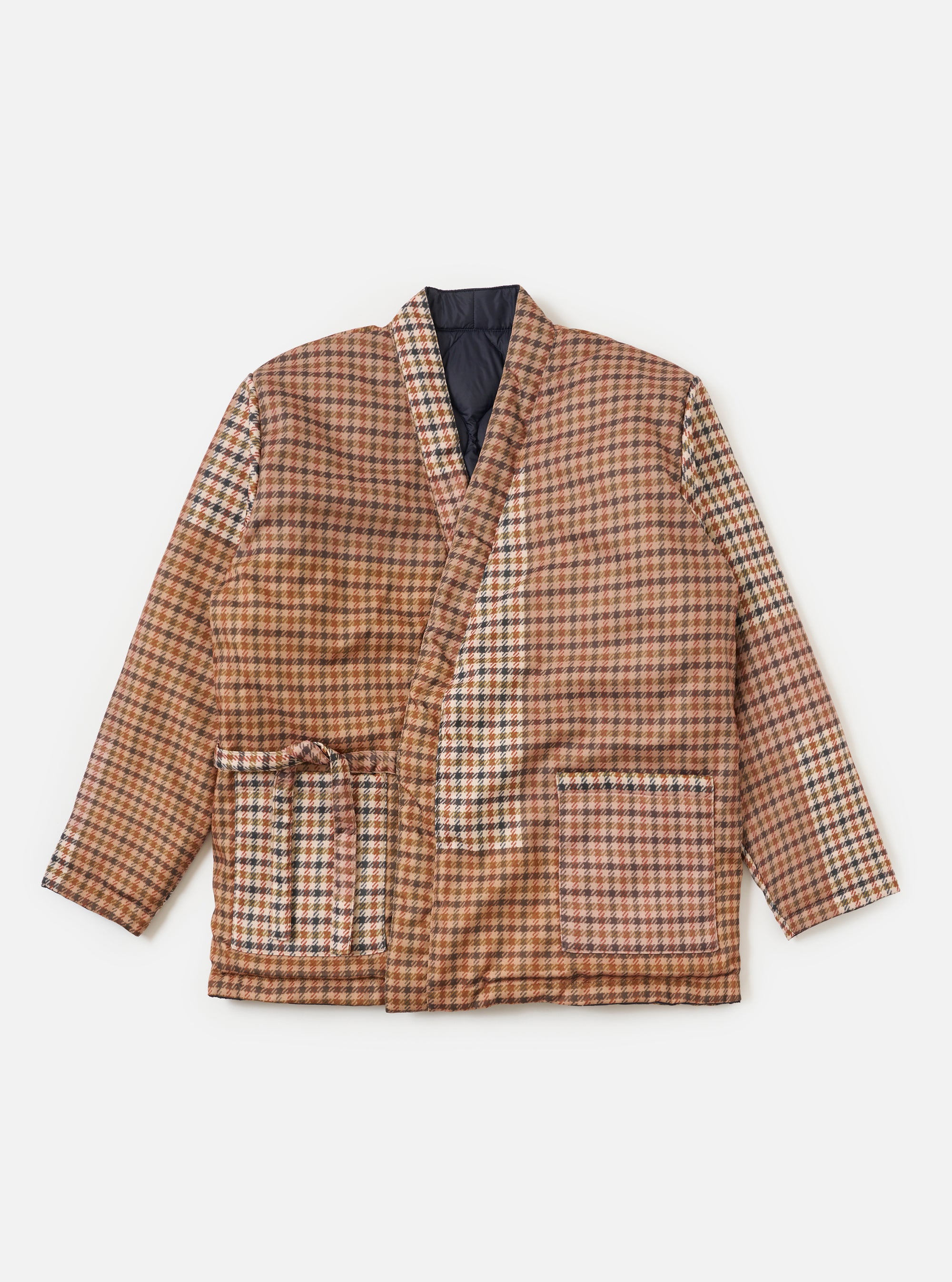 Flat lay of the TAION x Universal Works Reversible Dark Navy Military Line Kyoto Work Jacket. The jacket is brown plaid with a dark navy lining, on a white background.