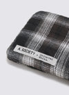 Close-up of A. SOCIETY x Universal Works Silver/Grey Kowloon Eyewear case. Plaid pattern in silver and grey tones. The product label is visible on a white background.