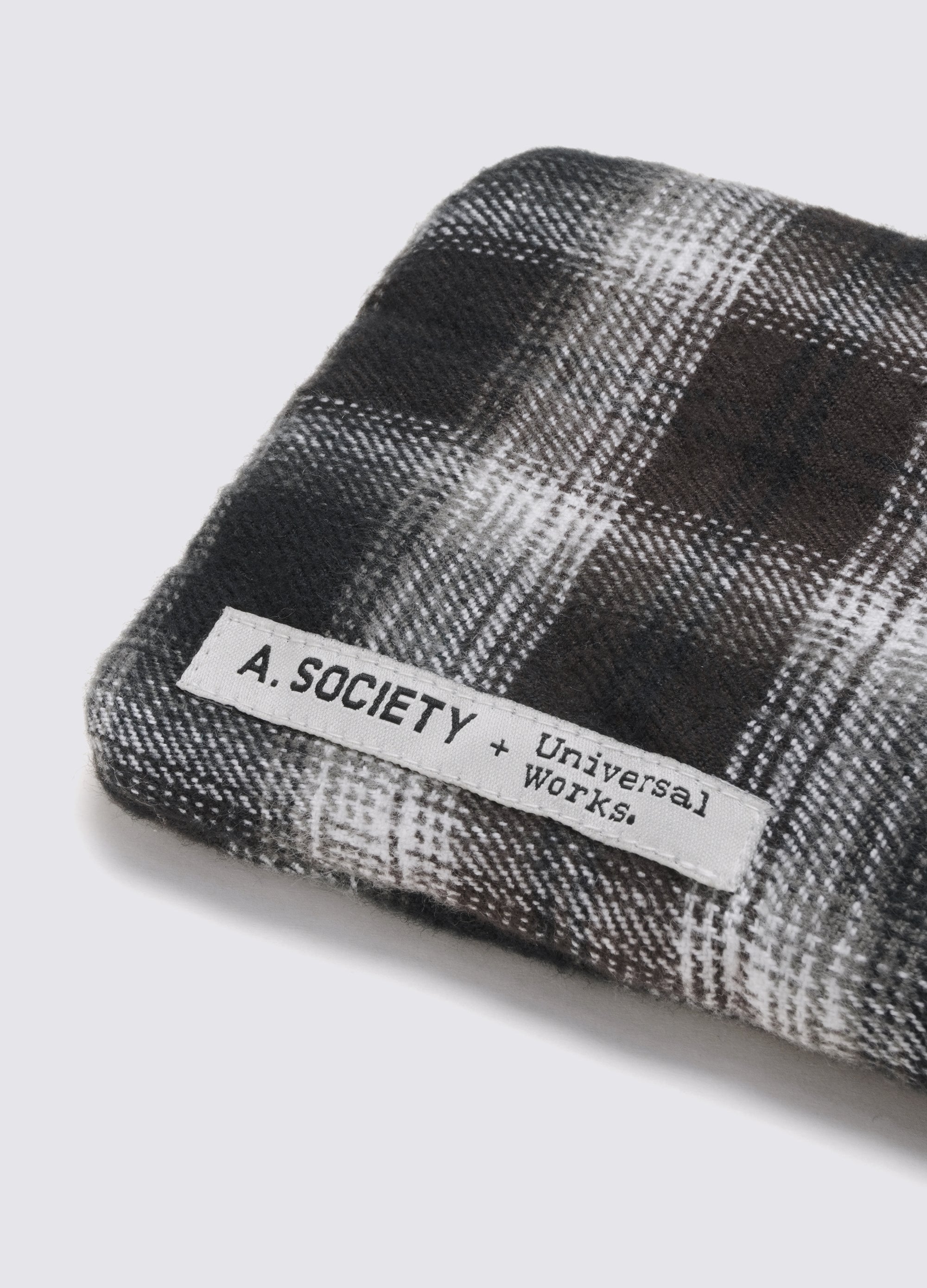Close-up of the A. SOCIETY x Universal Works Navy Aberdeen Sunglasses case, featuring a navy and white plaid pattern. The product label is visible on a plain white background.
