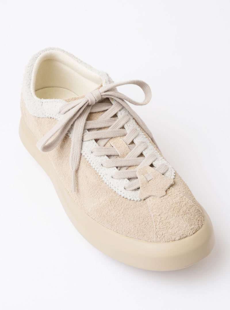 The Wander etc. 'The 70's' in Bone Hairy Suede/Leather is shown from a rear three-quarter angle as a flat lay against a plain white background. The image highlights the shoe's textured bone-colored hairy suede upper, the chunky off-white midsole, and the black rubber outsole. The heel features a vertical leather strip and tonal stitching.