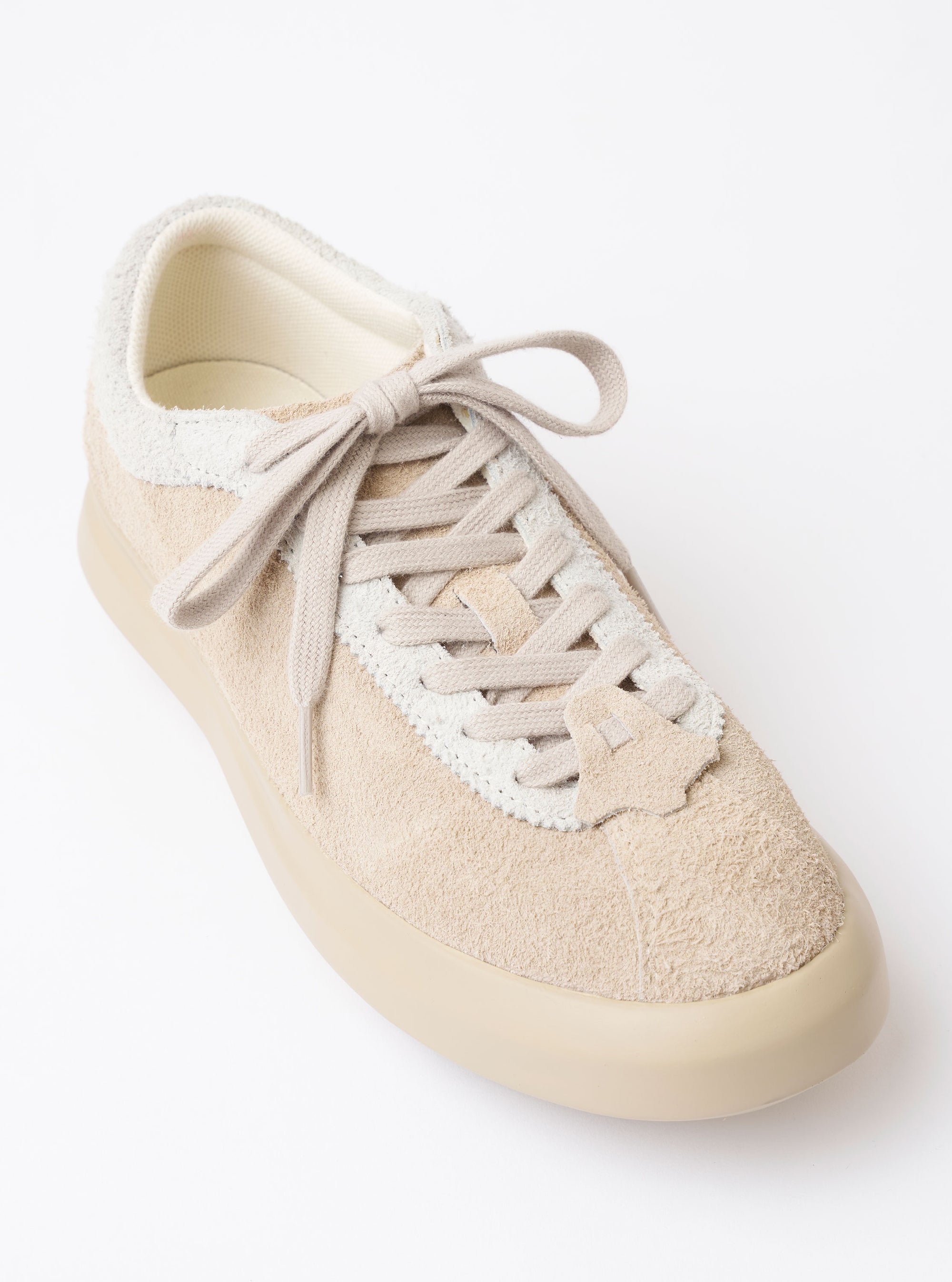The Wander etc. 'The 70's' in Bone Hairy Suede/Leather is shown from a rear three-quarter angle as a flat lay against a plain white background. The image highlights the shoe's textured bone-colored hairy suede upper, the chunky off-white midsole, and the black rubber outsole. The heel features a vertical leather strip and tonal stitching.