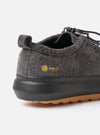 The Wander etc. FD/08 Low in Black Asphalt/Gum Hairy Suede is shown from a rear angle as a product shot against a plain white background. The image highlights the textured black hairy suede upper and the prominent chunky gum-colored rubber sole. The low-cut design features a vertical pull loop at the heel and tonal black stitching.