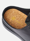 The Wander etc. Laze in Black Nappa Leather is shown as a flat lay against a plain white background. The image highlights the backless mule design, featuring a smooth black nappa leather upper and a chunky, textured black outsole.
