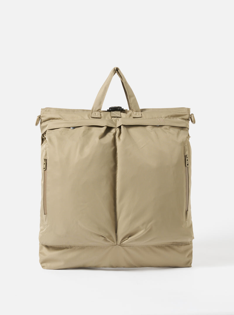 The F/CE.® Sage Green Recycled Twill 3-Way Helmet Bag is displayed on a white background. The bag is sage green and made of recycled twill. It has a top handle and two front pockets.