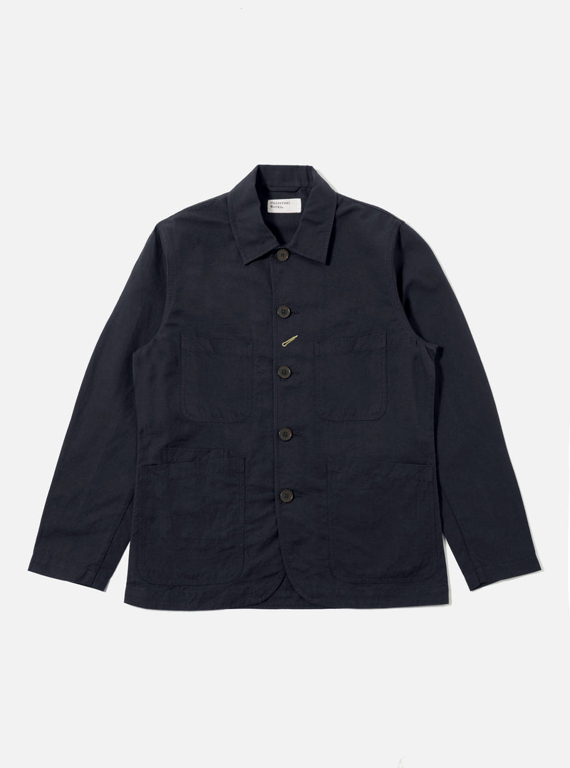 The Navy Linen Slub Weave Bakers Jacket, in navy linen, is laid flat on a white background. The jacket has a button-up front and four pockets.