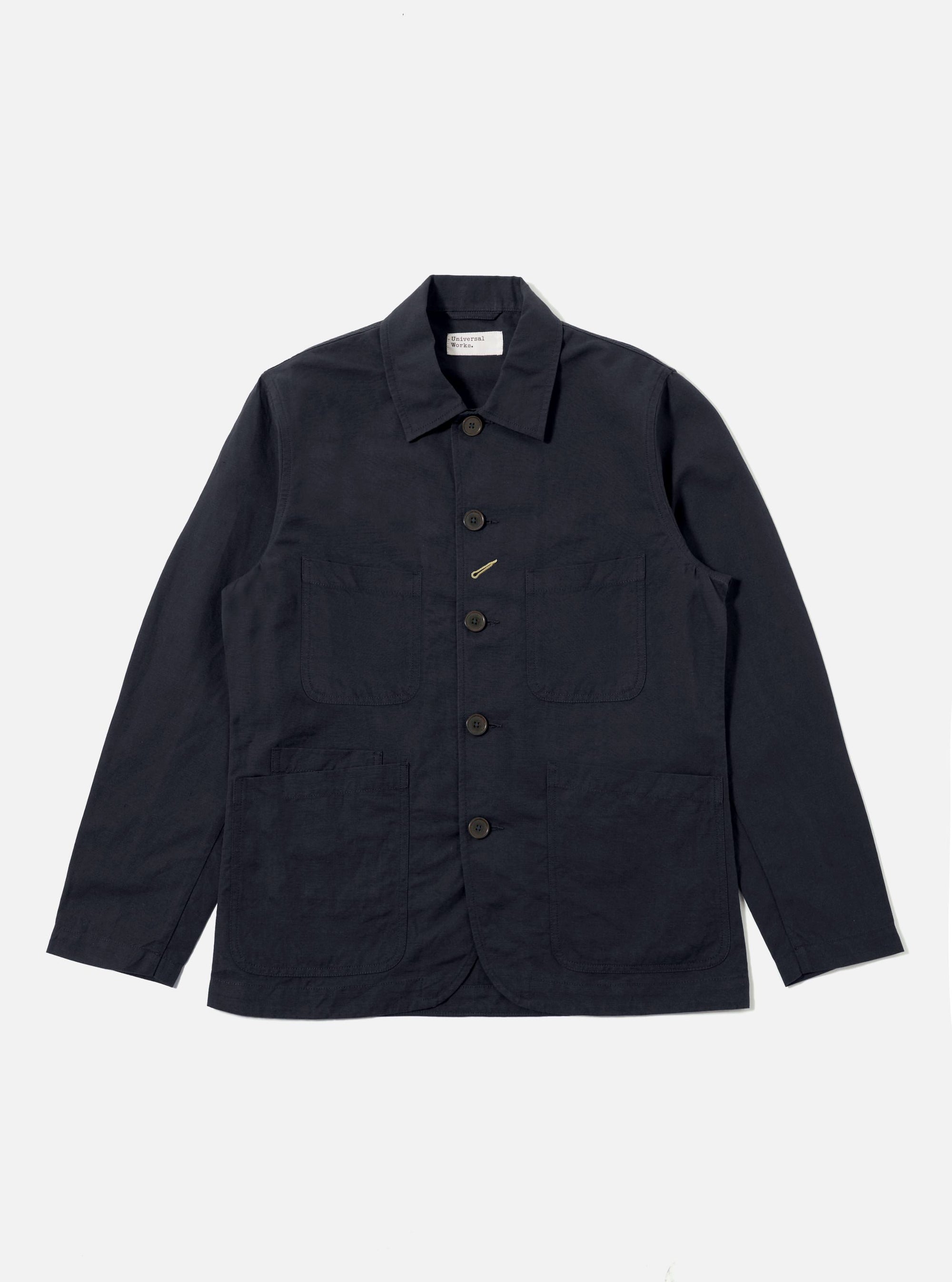 The Navy Linen Slub Weave Bakers Jacket, in navy linen, is laid flat on a white background. The jacket has a button-up front and four pockets.