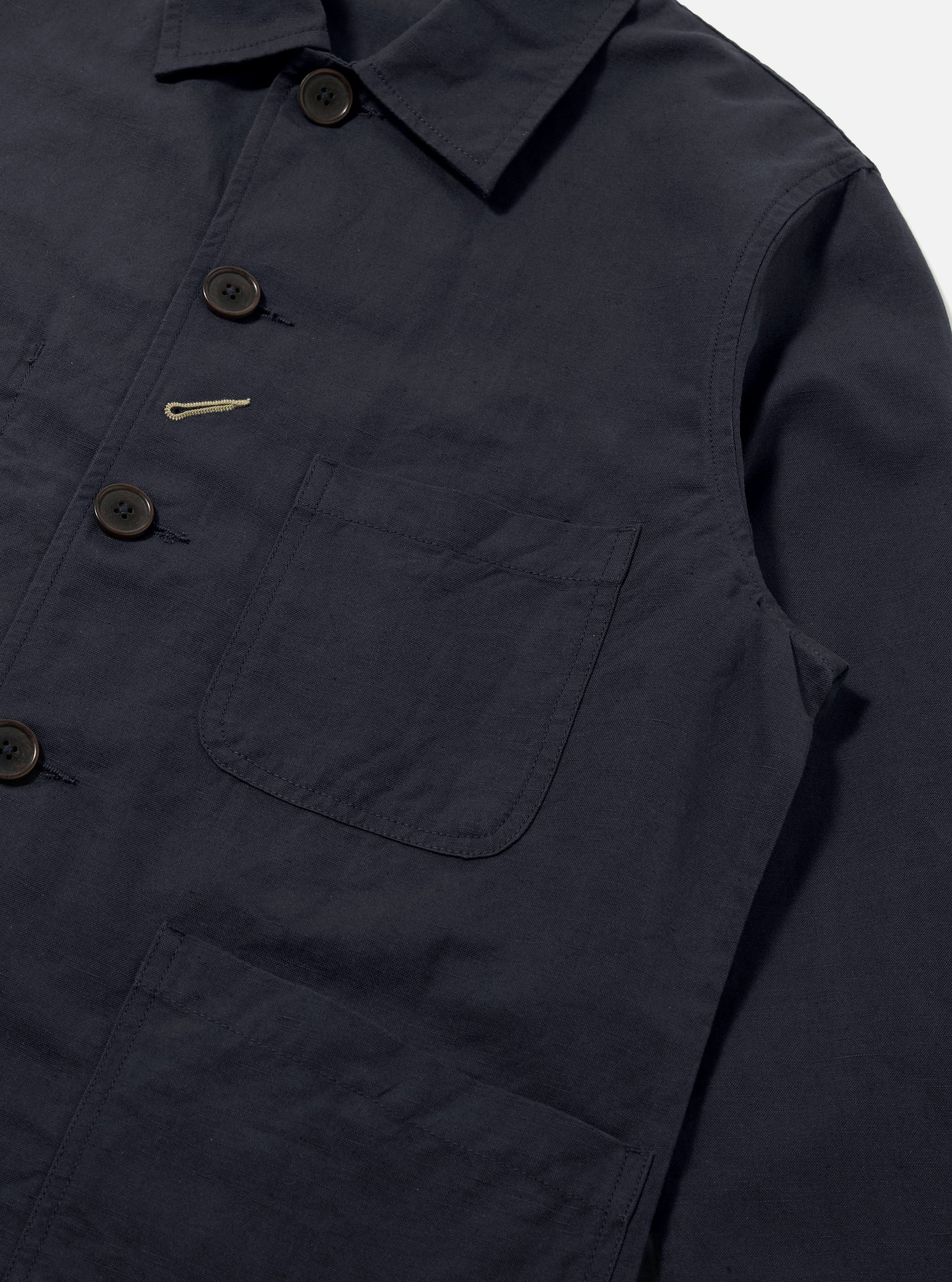 Close-up of the Navy Linen Slub Weave Bakers Jacket on a white background. The jacket features a button-up front and patch pockets.
