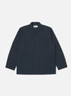The Navy Broadcloth Cancun Jacket is displayed on a white background. The jacket is a dark navy color and has a relaxed fit. It features a button-down front and three pockets.