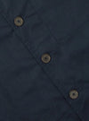 Close up of the navy Broadcloth Cancun Jacket. The jacket is made of broadcloth and has a relaxed fit. The background is a plain white surface.
