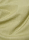 Close-up of the pale green broadcloth fabric of the Cancun Jacket, showing its texture and color. The jacket is draped on a flat surface.