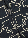 Close-up of the Navy Mitla Broadcloth Club Jacket. The jacket is navy with a white geometric pattern and a silver zipper. The background is a plain surface.