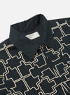 Close-up of the Navy Mitla Broadcloth Club Jacket on a white surface. The jacket is navy with a white geometric pattern and a silver zipper.