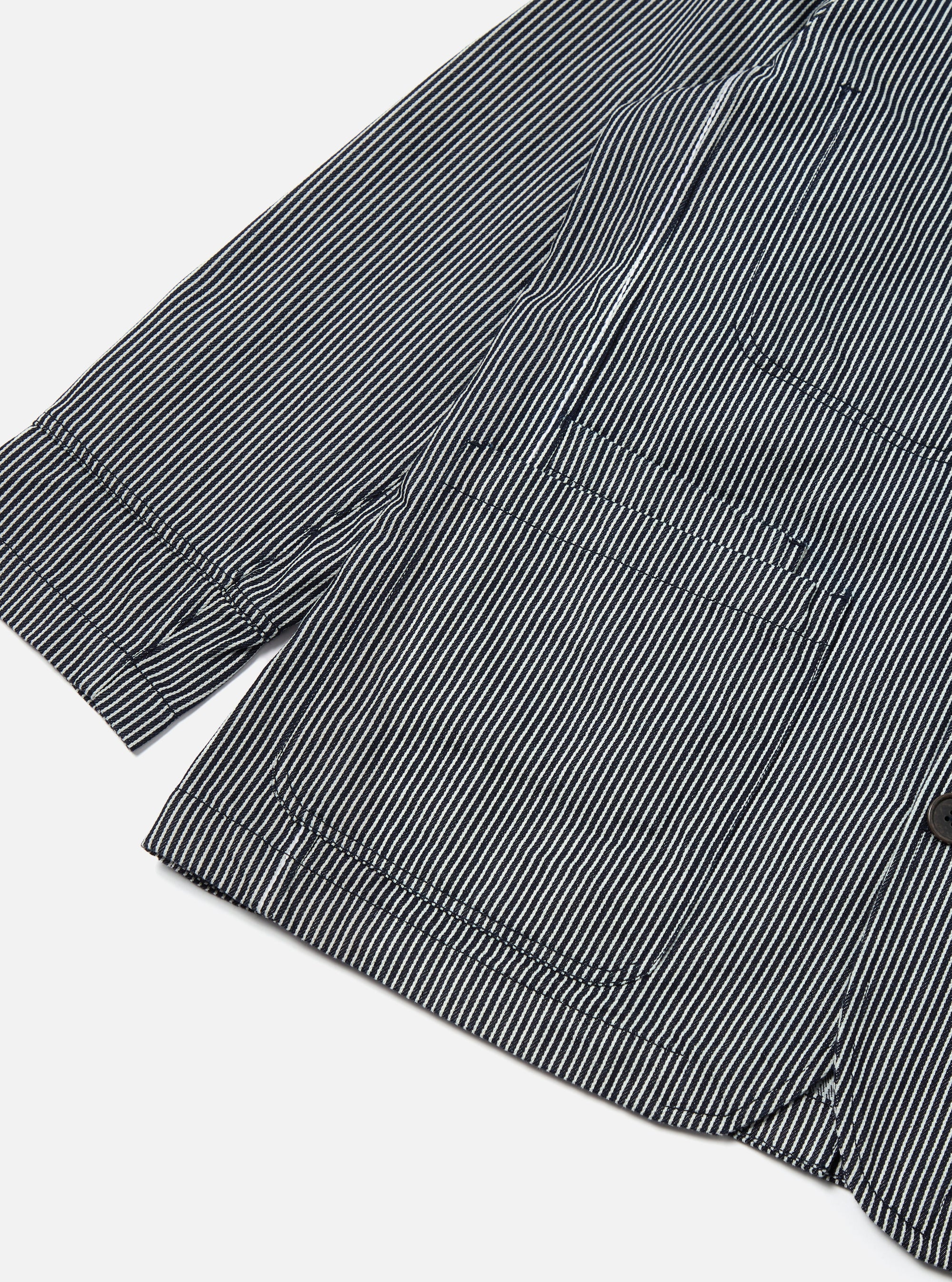 Close-up of the Indigo Hickory Stripe Denim Original Bakers Jacket on a white background, showing the striped pattern and pocket detail.