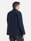 A man wears the Navy Broadcloth Osaka Work Jacket in a studio shot against a white backdrop. The jacket is a relaxed fit, broadcloth material. He's also wearing patterned pants.