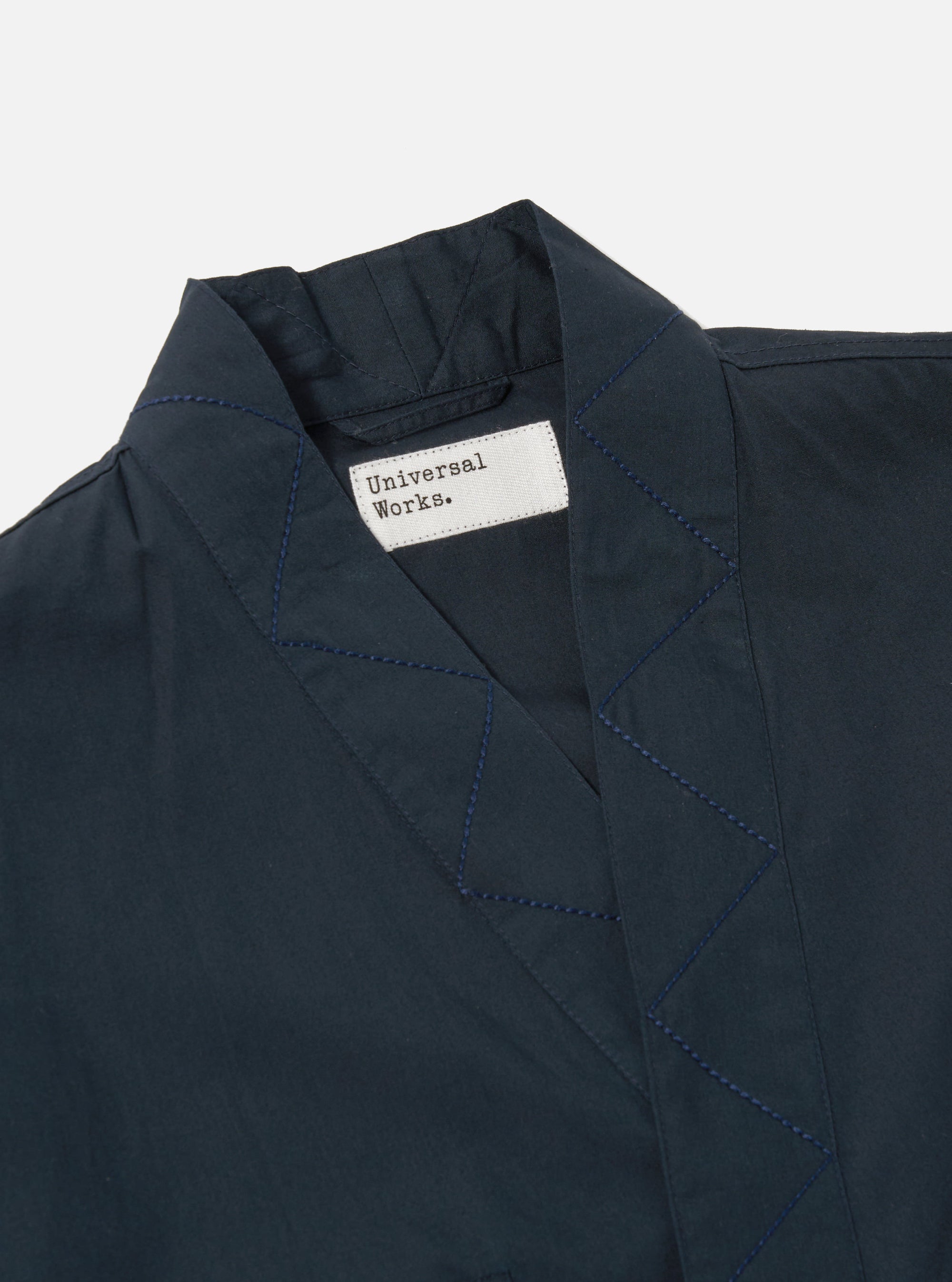Close-up of the Navy Broadcloth Osaka Work Jacket on a white background. The jacket is broadcloth and features a collar and blue stitching.