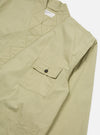 Close-up of the pale green Broadcloth Osaka Work Jacket on a white surface. The broadcloth material has a pocket with a button. The jacket has a unique collar.