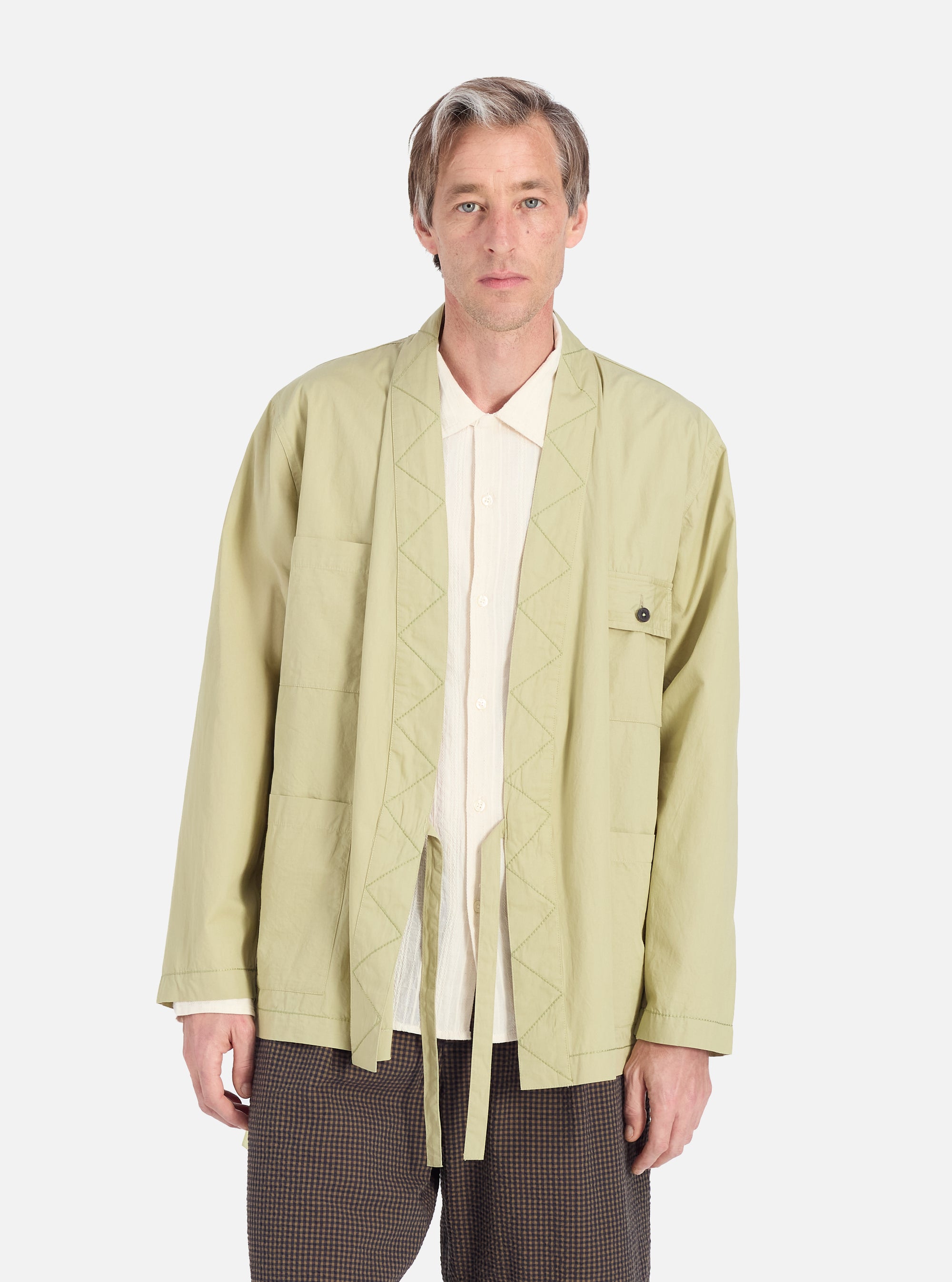 Model wears a Pale Green Broadcloth Osaka Work Jacket in front of a white background. The jacket is broadcloth with a tie waist and patch pockets.