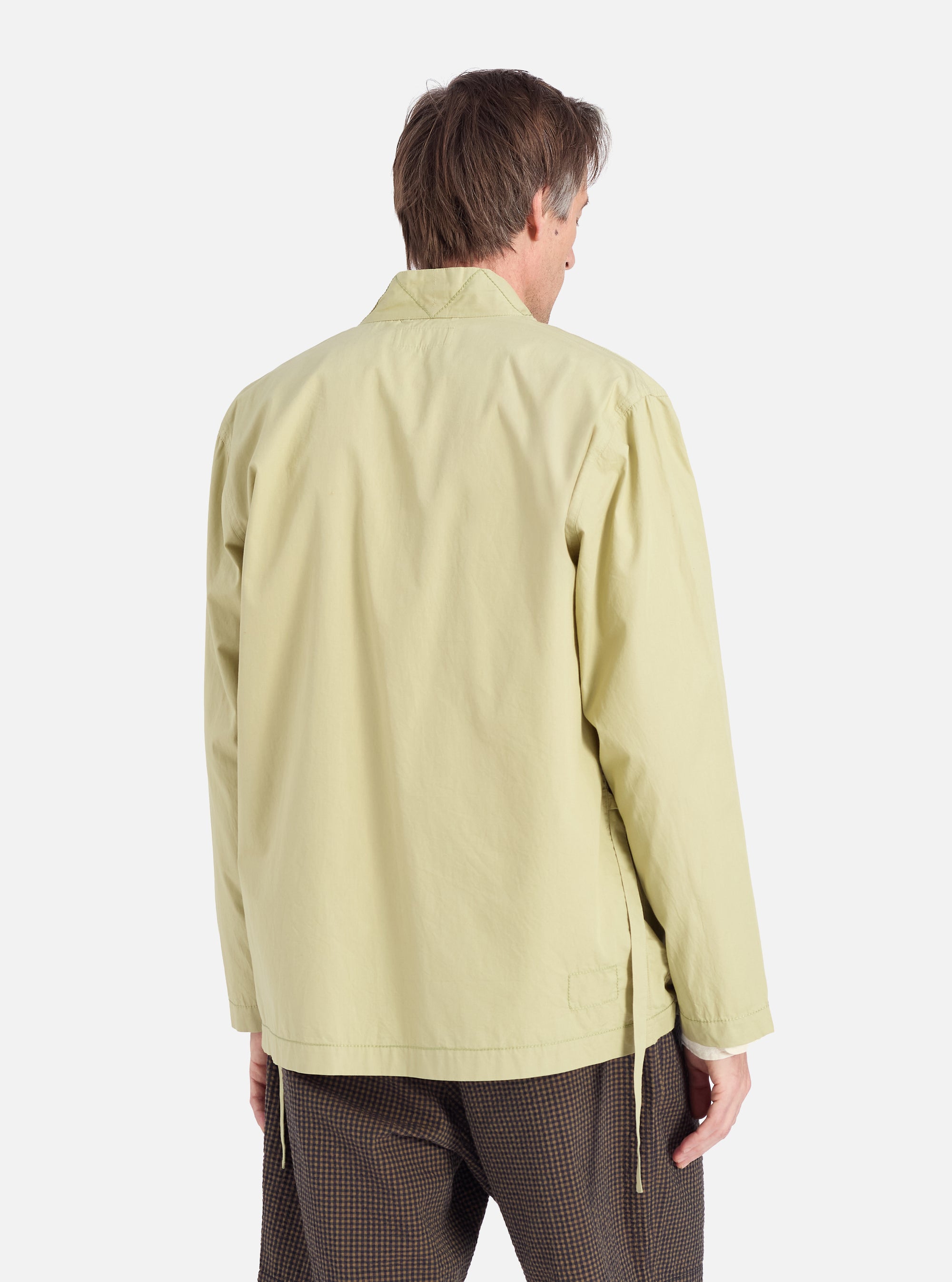 Back view of a model wearing a Pale Green Broadcloth Osaka Work Jacket. The jacket is broadcloth and pale green. The background is a plain white studio.