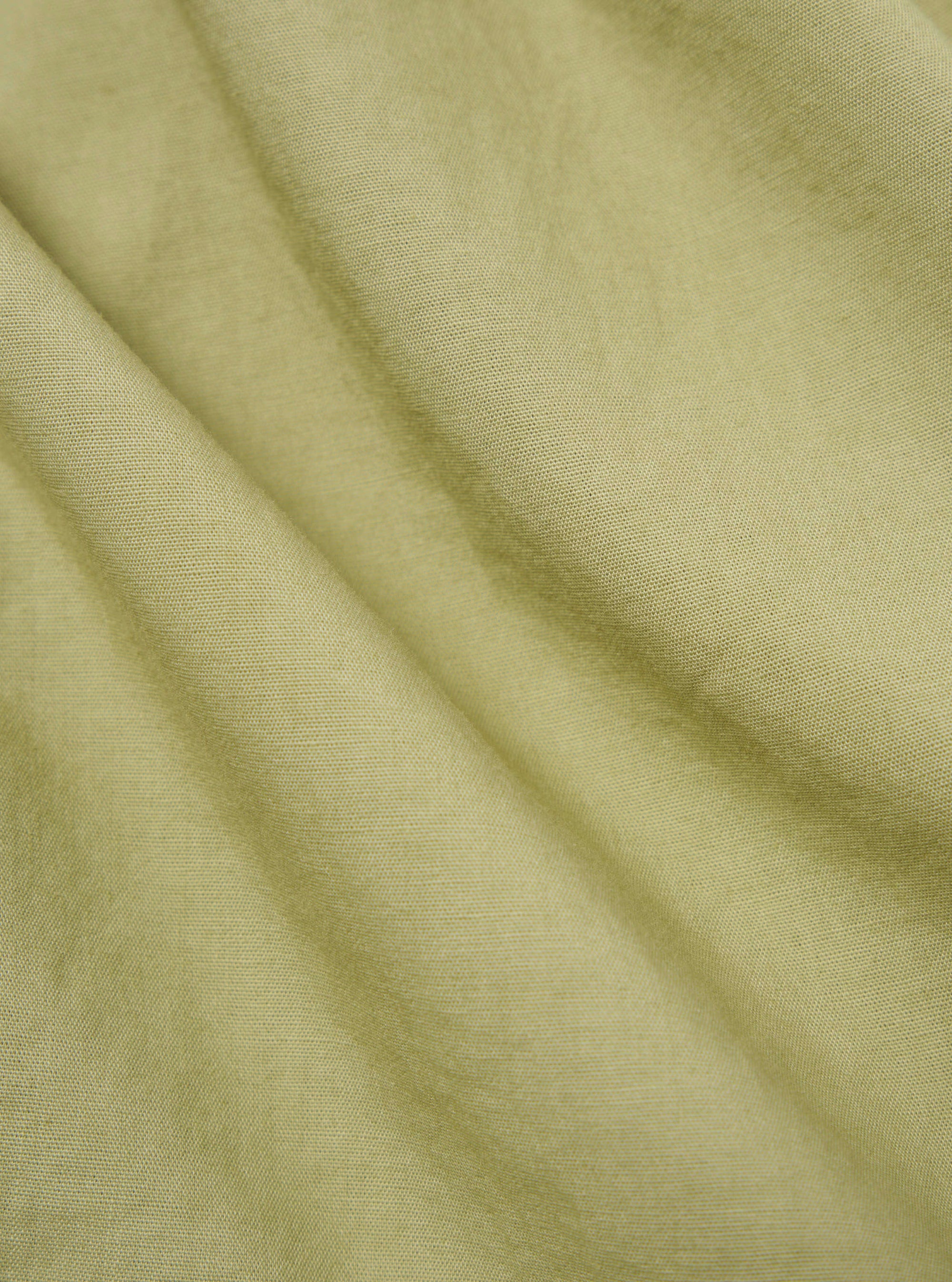 Close-up of the pale green broadcloth Osaka work jacket fabric. The material is draped to show texture and color.