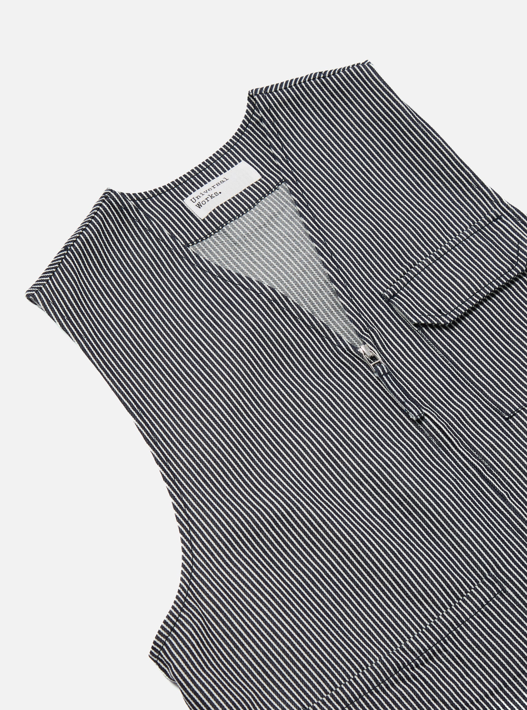 Close-up of the Indigo Hickory Stripe Denim Marine Gilet, a sleeveless denim vest with a vertical stripe pattern, zip closure, and chest pocket, staged on a white background.