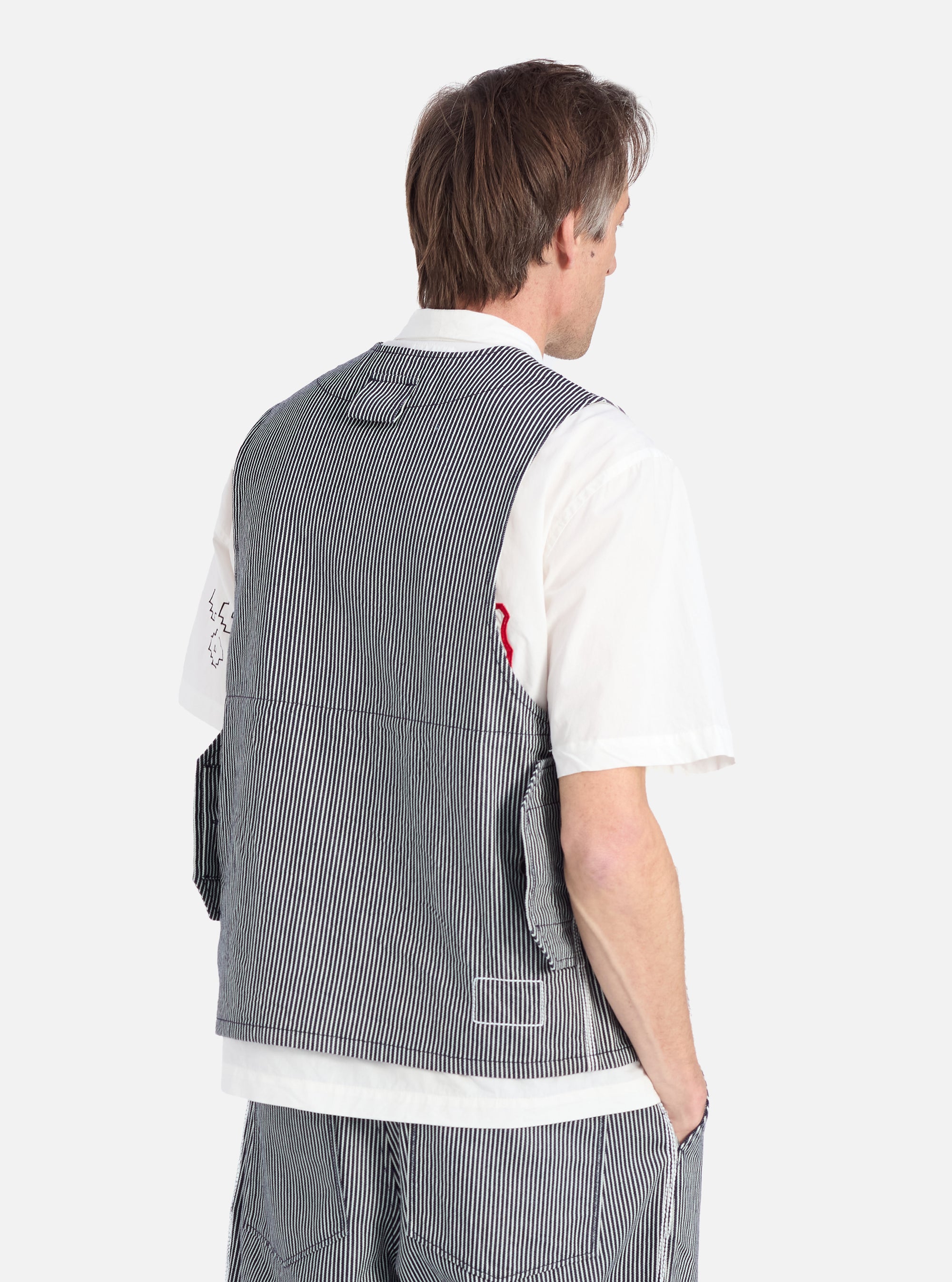 Back view of a model wearing the Indigo Hickory Stripe Denim Marine Gilet over a white shirt, against a white background. The gilet features a striped denim pattern.