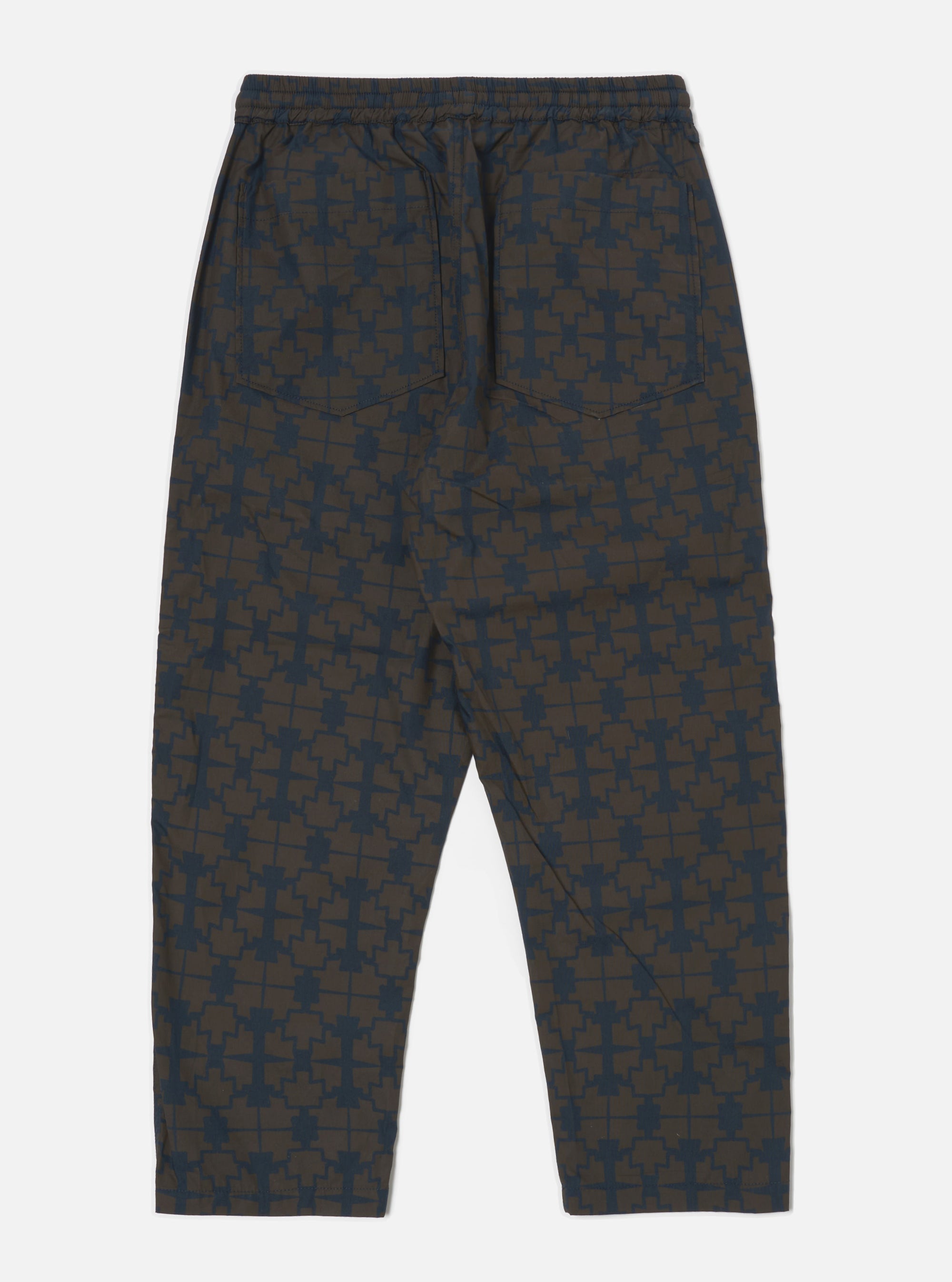 Back view of the Navy Mitla Print Cotton Hi Water Trouser on a white background. The trousers feature a navy print on a brown cotton fabric and a relaxed fit.
