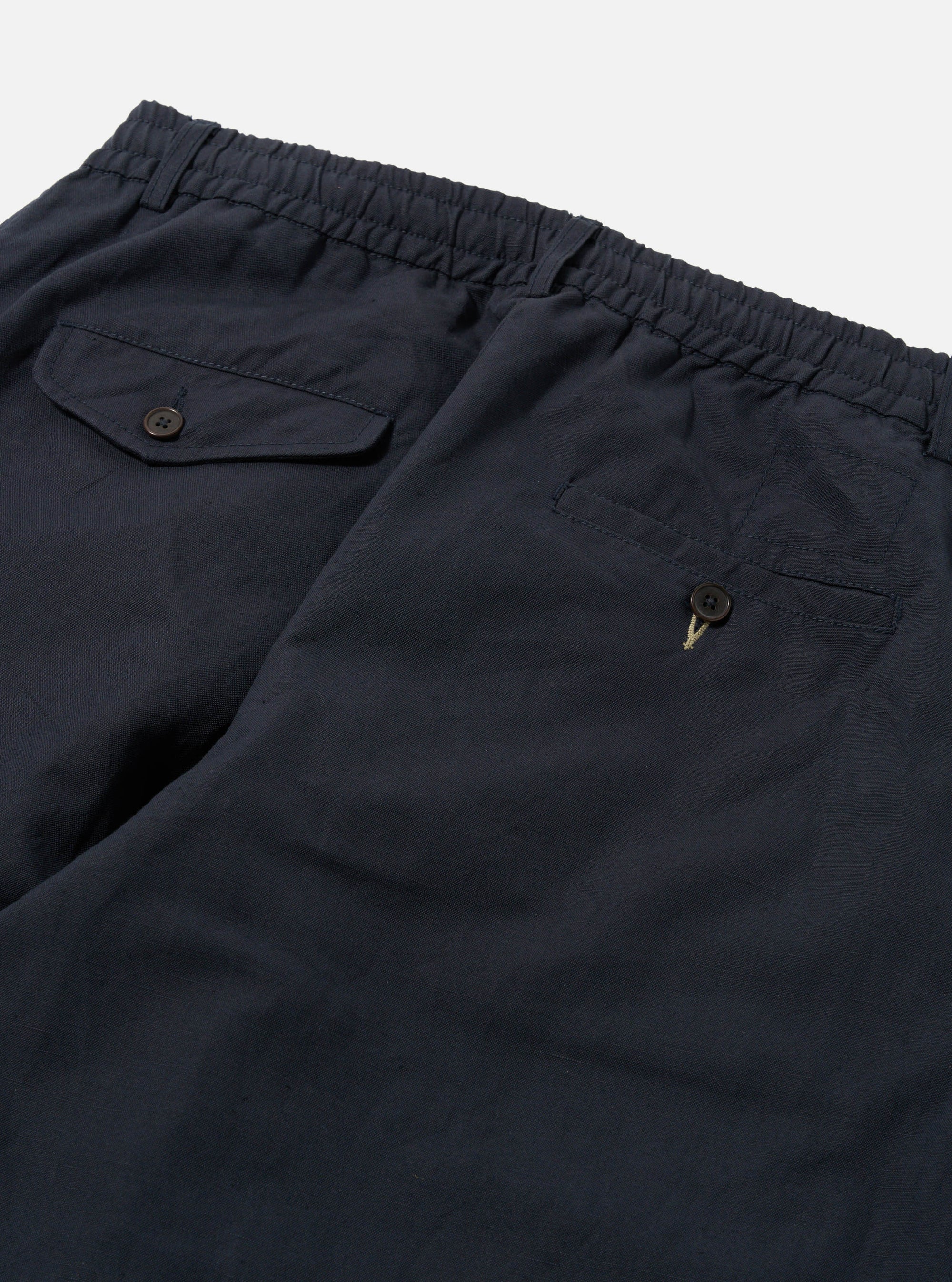 Close-up of the back of Navy Linen Slub Weave Oxford Pant on a white background. Shows the elastic waistband and buttoned pockets.