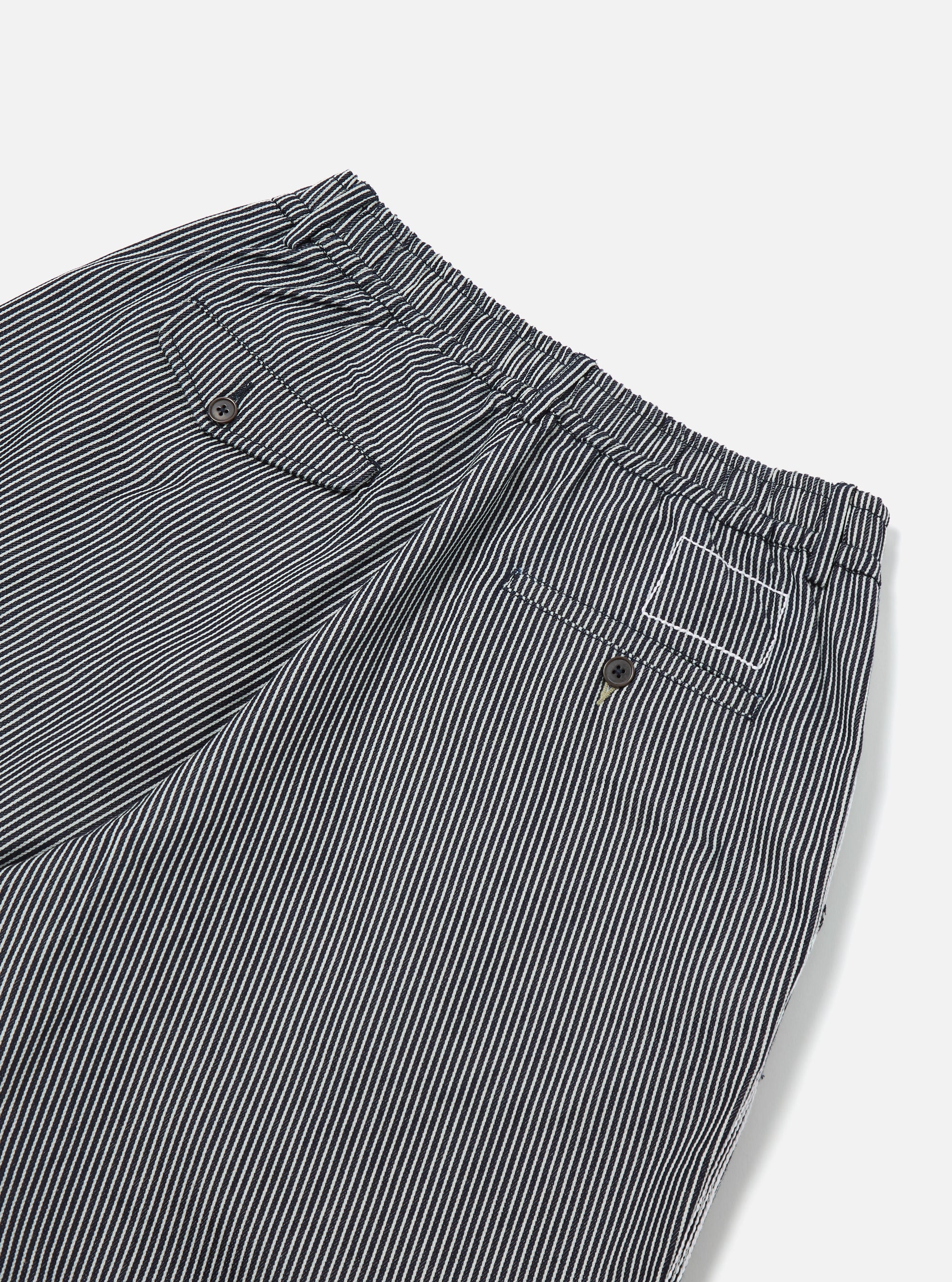 Close-up of Indigo Hickory Stripe Denim Pleated Track Short showing the striped denim material, pleated details, and back pockets on a clean white background.