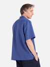 Profile of a man wearing a Blue Linen Cotton Shirting Camp Shirt. The shirt is a relaxed fit. Shot against a white background.