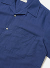 Close-up of the Blue Linen Cotton Shirting Camp Shirt on a white surface. The shirt is a rich blue with a camp collar, chest pocket, and button closure.
