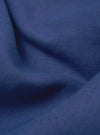 Close-up of the blue linen cotton shirting camp shirt fabric. The material is draped to show texture and color.